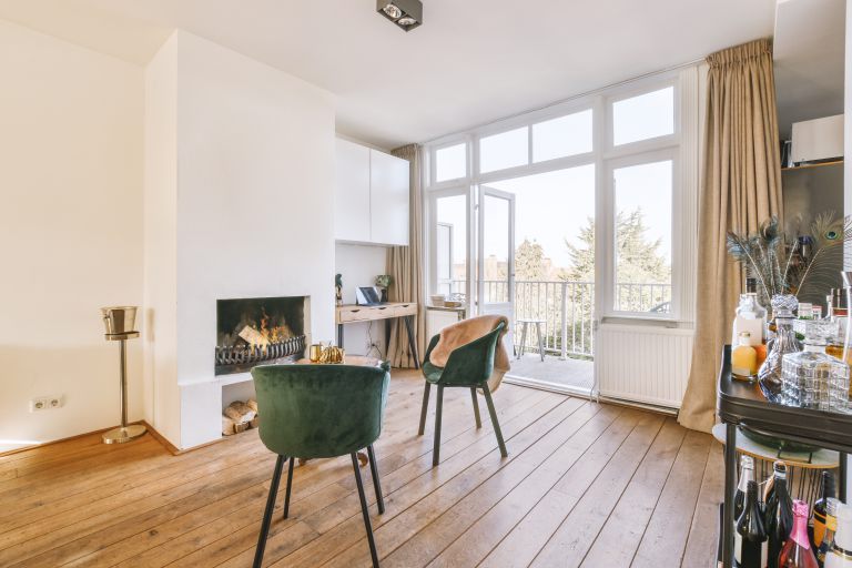 Living room with chairs, working area near fireplace and drinks rack